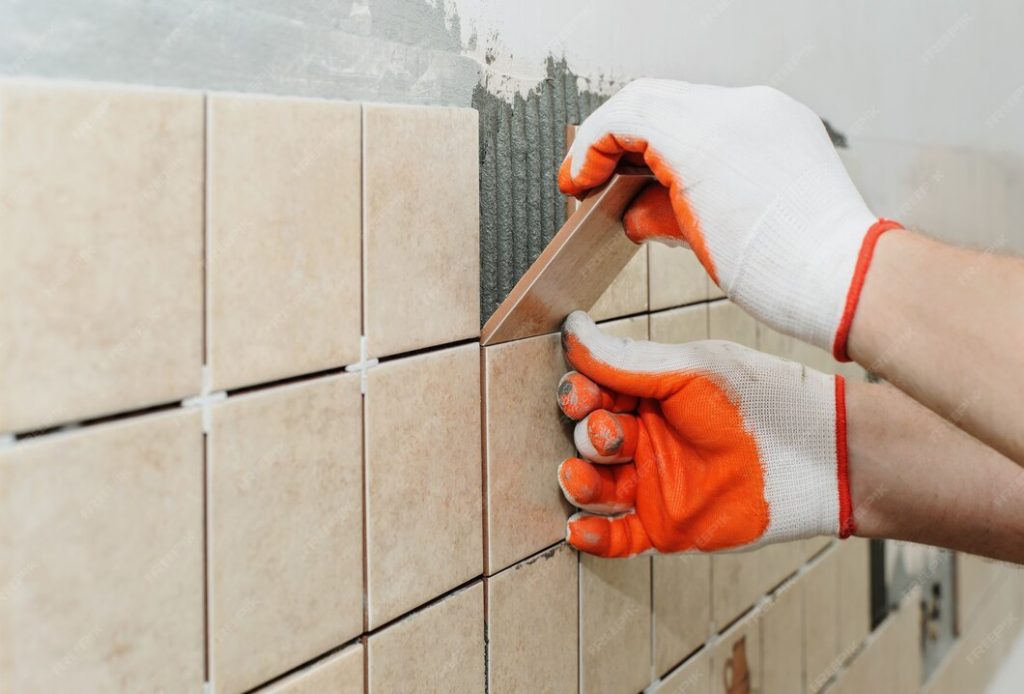 worker-sets-tiles-wall-kitchen-his-hands-are-placing-tile-adhesive